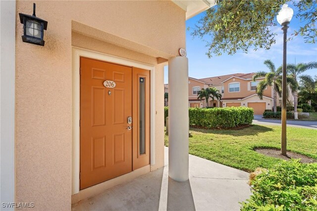 entrance to property featuring a lawn