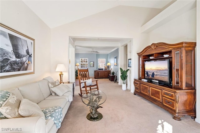 carpeted living room with ceiling fan and vaulted ceiling