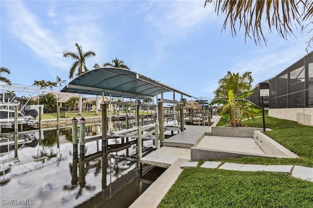 view of dock with a lawn and a water view