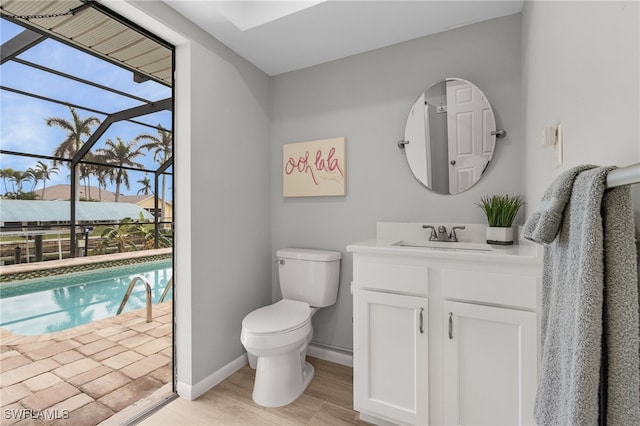 bathroom featuring wood-type flooring, vanity, toilet, and plenty of natural light