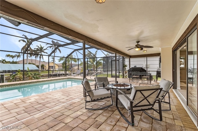 view of pool featuring glass enclosure, ceiling fan, and a patio area