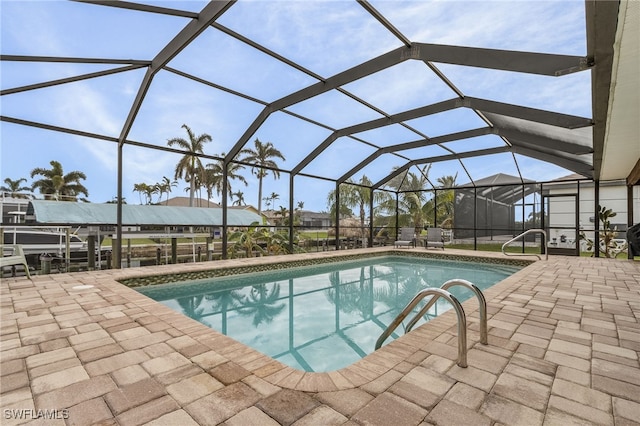 view of pool featuring glass enclosure and a patio area