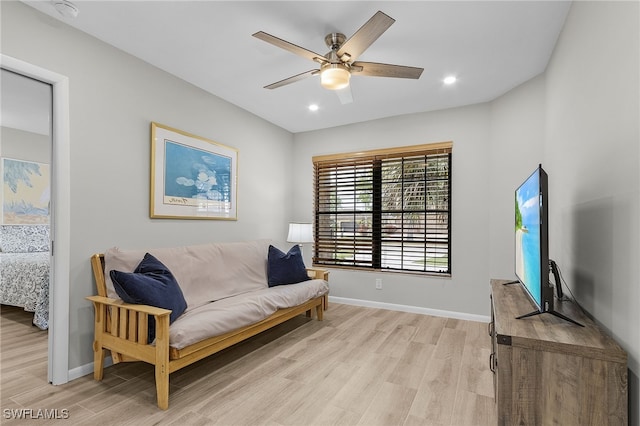 sitting room with ceiling fan and light hardwood / wood-style flooring