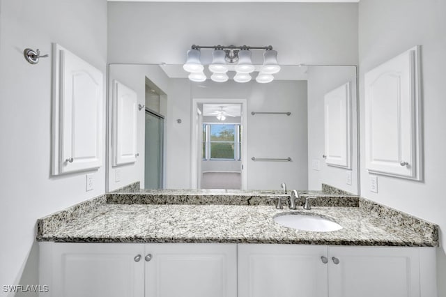 bathroom with ceiling fan, a shower with door, and vanity