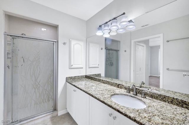 bathroom featuring vanity, tile patterned floors, and a shower with shower door