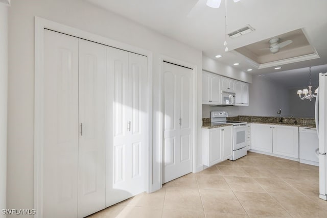 kitchen with white cabinets, ceiling fan with notable chandelier, white appliances, and sink