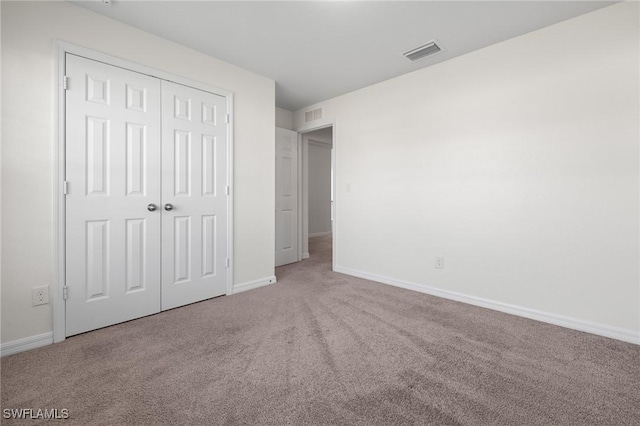 unfurnished bedroom with carpet and a closet