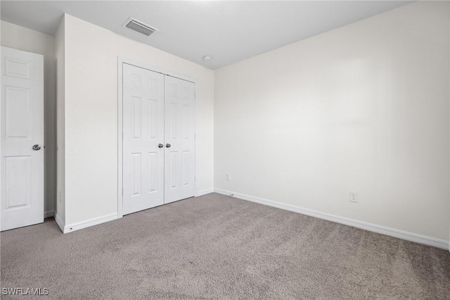 unfurnished bedroom featuring carpet flooring and a closet