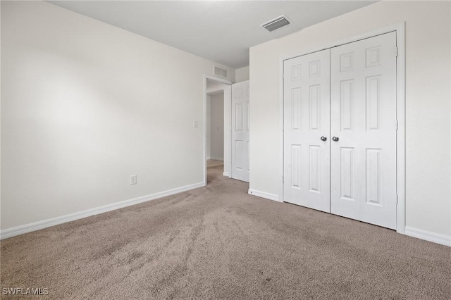 unfurnished bedroom featuring carpet and a closet