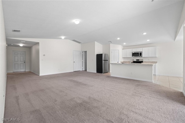 unfurnished living room featuring light carpet and vaulted ceiling