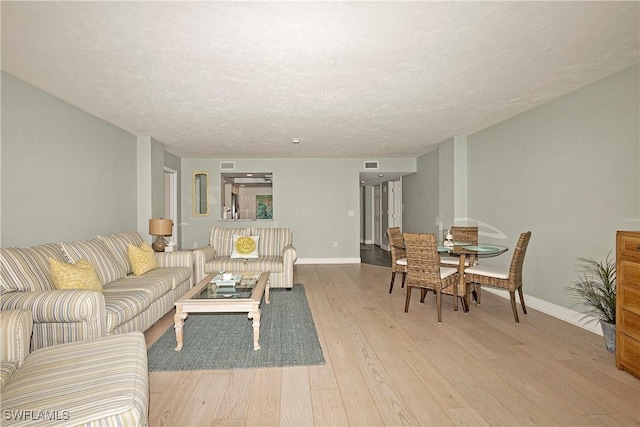 living room featuring a textured ceiling and light hardwood / wood-style flooring