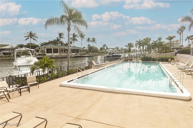 view of pool with a water view and a patio area