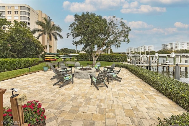 view of patio / terrace featuring a boat dock, a water view, and a fire pit