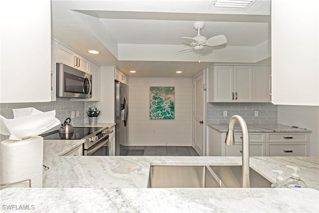 kitchen featuring backsplash, stainless steel appliances, white cabinetry, and sink