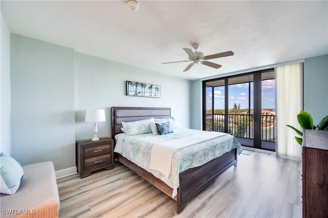 bedroom featuring access to exterior, ceiling fan, a wall of windows, light wood-type flooring, and baseboards