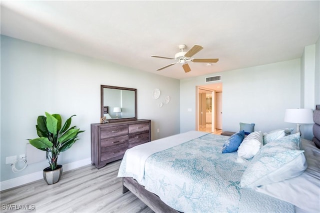 bedroom featuring light wood finished floors, baseboards, visible vents, and ceiling fan