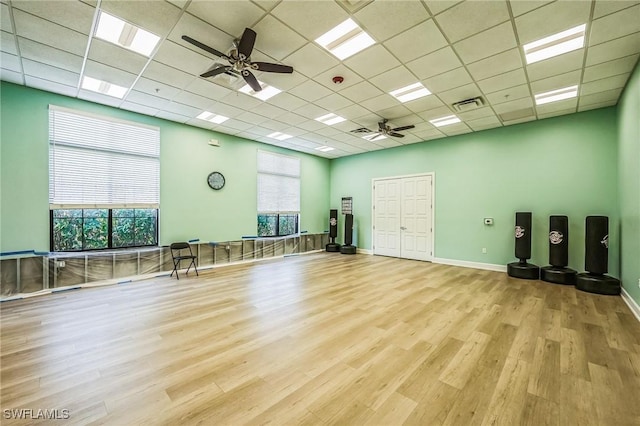 exercise area featuring a paneled ceiling, plenty of natural light, and light hardwood / wood-style flooring