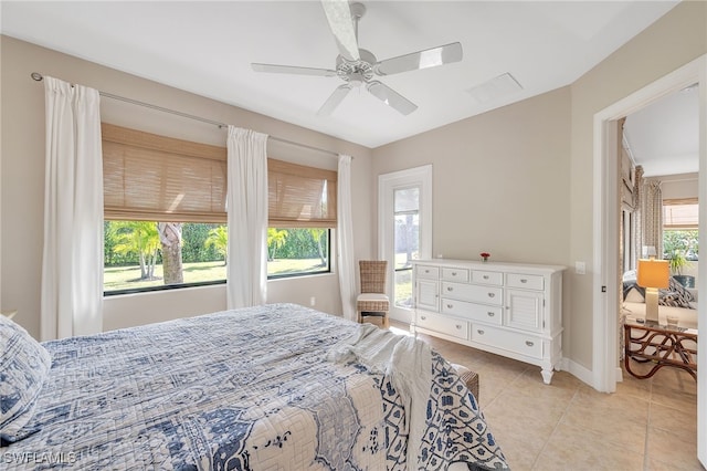 bedroom with ceiling fan, light tile patterned floors, and multiple windows