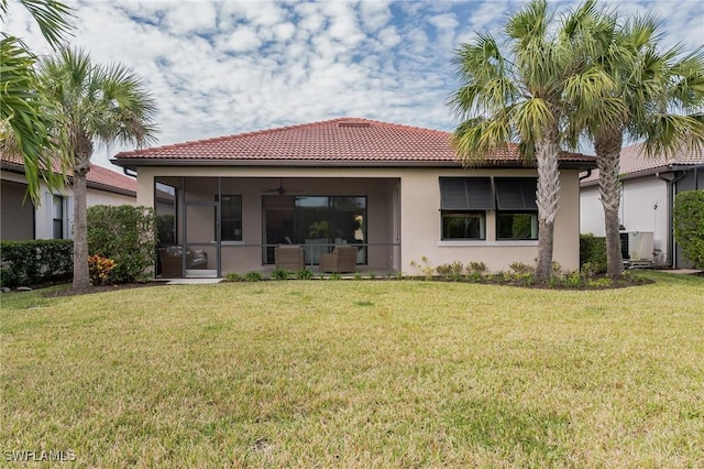 rear view of house with a yard and ceiling fan