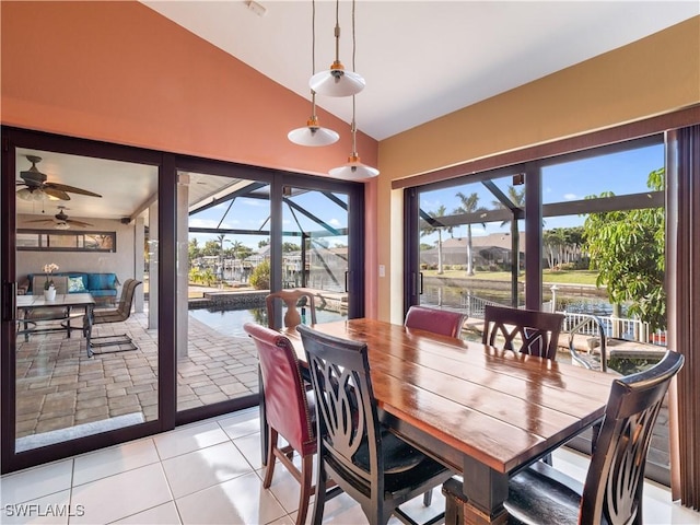 dining area with ceiling fan, light tile patterned floors, lofted ceiling, and a wealth of natural light