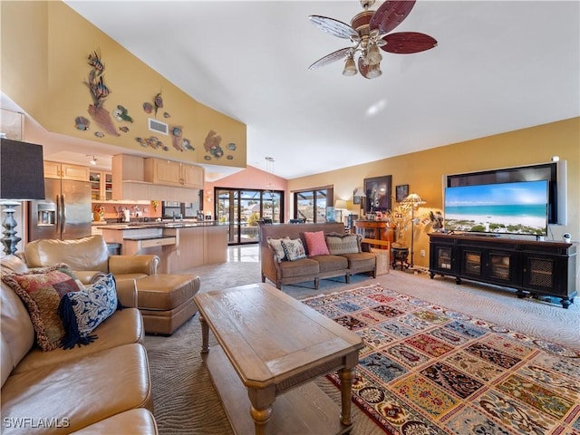 carpeted living room featuring ceiling fan and high vaulted ceiling