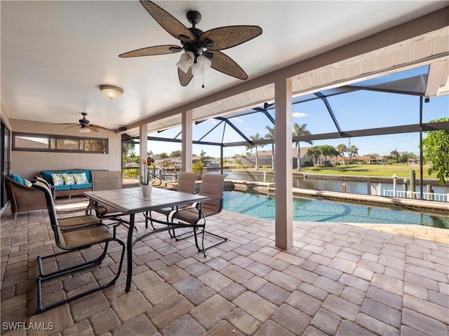 view of swimming pool with a patio area, a water view, ceiling fan, a lanai, and an outdoor living space