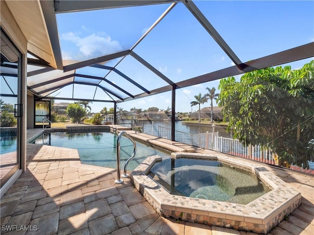 view of pool with an in ground hot tub, a patio area, glass enclosure, and a water view