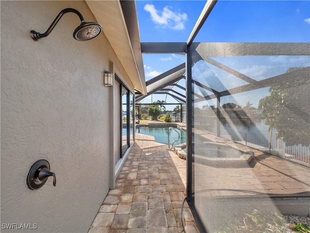 view of swimming pool with glass enclosure and a patio area