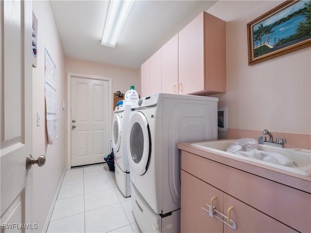 clothes washing area with cabinets, light tile patterned floors, separate washer and dryer, and sink