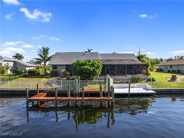 view of dock featuring a water view, a yard, and glass enclosure