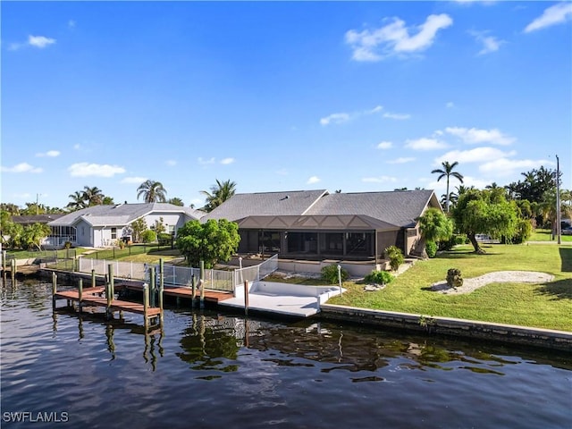 view of dock featuring glass enclosure, a lawn, and a water view