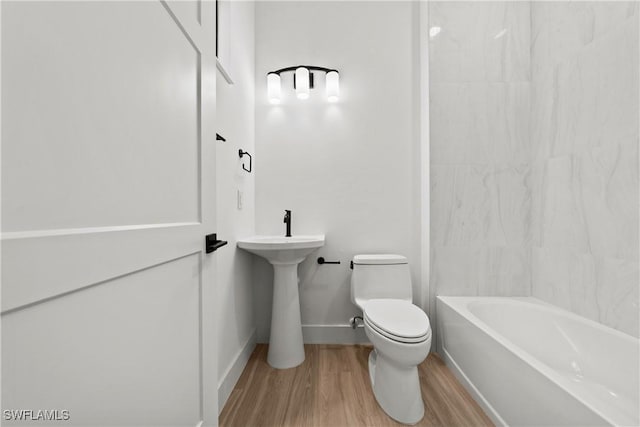 bathroom featuring hardwood / wood-style floors, toilet, and bathing tub / shower combination