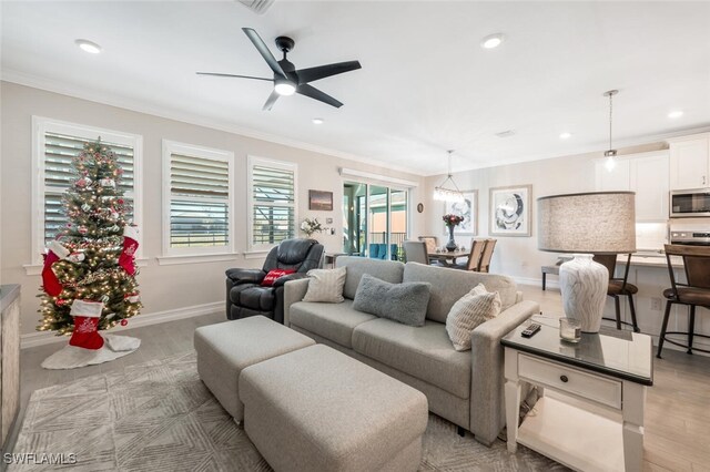 living room featuring ceiling fan, light hardwood / wood-style floors, and ornamental molding