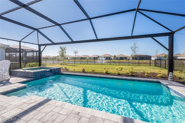 view of swimming pool with an in ground hot tub, a patio, glass enclosure, and a lawn