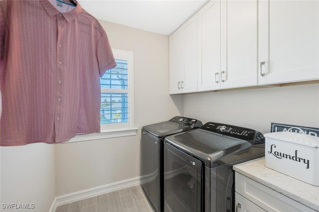 washroom featuring light hardwood / wood-style floors, cabinets, and separate washer and dryer