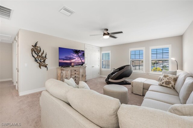 carpeted living room with ceiling fan