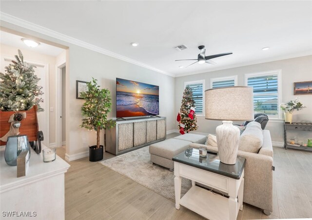 living room featuring crown molding, light hardwood / wood-style flooring, and ceiling fan