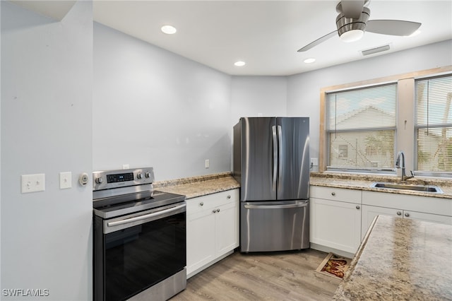 kitchen featuring ceiling fan, sink, light hardwood / wood-style flooring, white cabinets, and appliances with stainless steel finishes