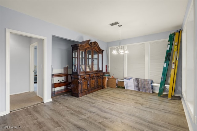 dining space featuring light hardwood / wood-style floors and a notable chandelier