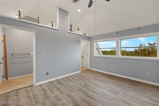 empty room featuring ceiling fan, light hardwood / wood-style floors, and high vaulted ceiling