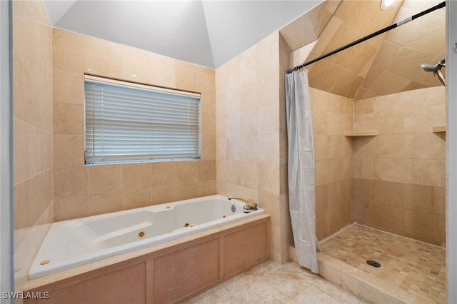 bathroom with tile patterned floors, tile walls, lofted ceiling, and shower with separate bathtub