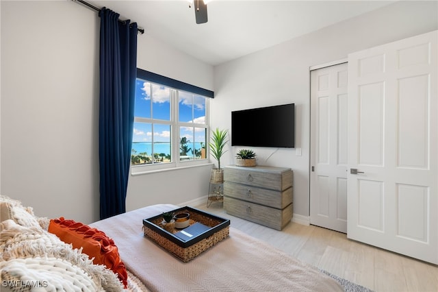 bedroom with ceiling fan, a closet, and light hardwood / wood-style floors