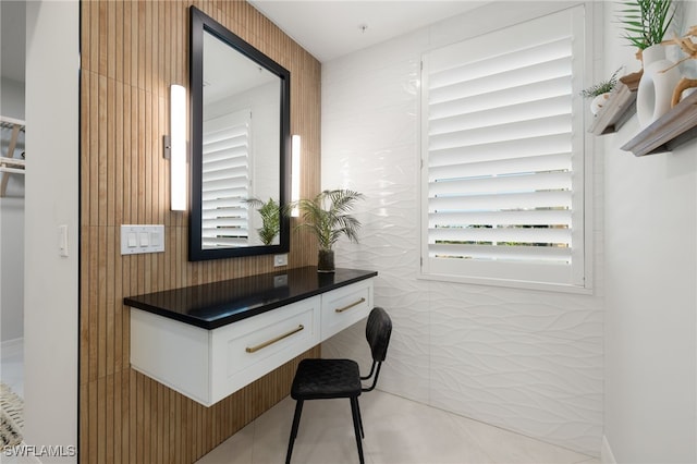 office space with light tile patterned flooring and tile walls