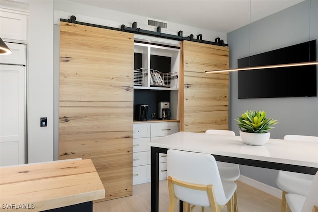 office space featuring a barn door and light hardwood / wood-style flooring