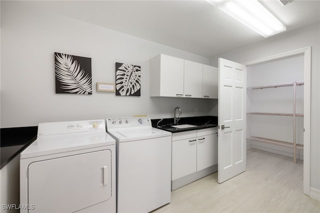 washroom with cabinets, sink, and washing machine and dryer