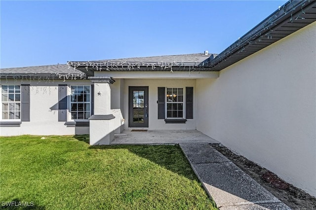 property entrance with a lawn