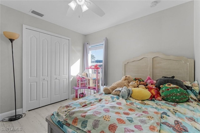 bedroom with ceiling fan, a closet, and light hardwood / wood-style floors