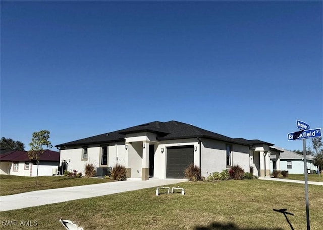 prairie-style home featuring central air condition unit, a front lawn, and a garage