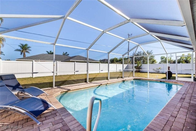 view of swimming pool with a patio, glass enclosure, and a lawn