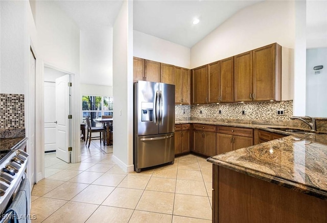 kitchen with decorative backsplash, sink, light tile patterned floors, and stainless steel appliances